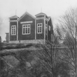 Ett hus med torn på ett berg.