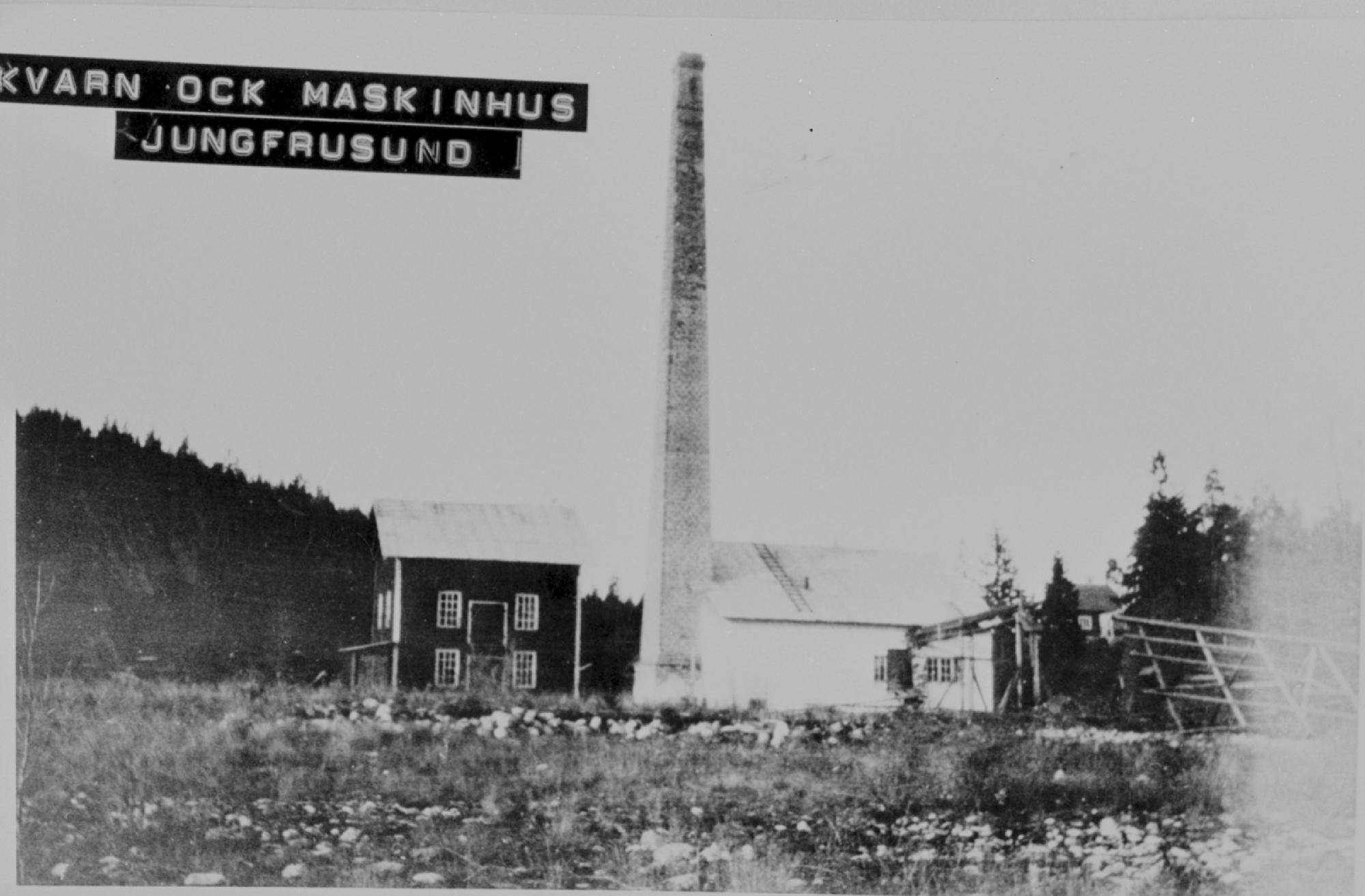 Ett svartvitt foto av två hus, det ena med en mycket hög skorsten.