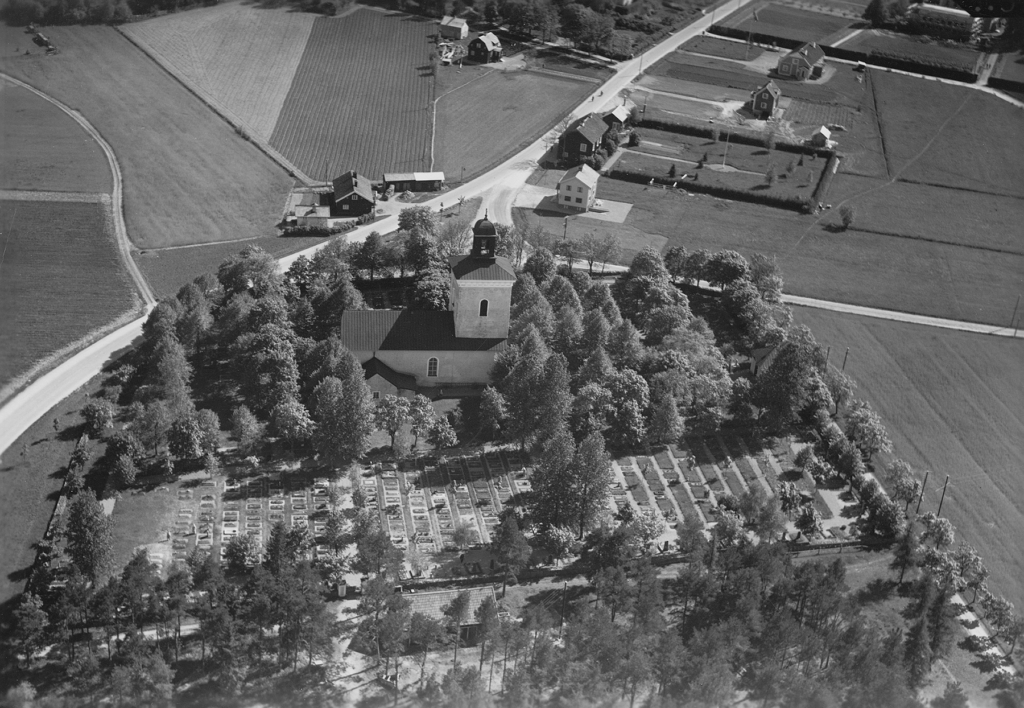 Svartvitt flygfoto över Fasterna kyrka och kringliggande landskap