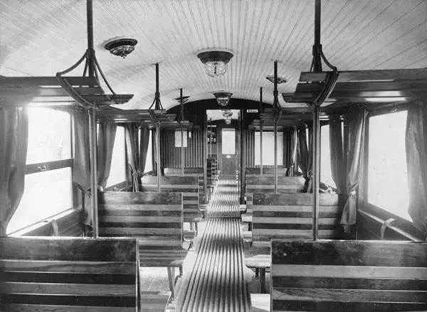 Svartvitt foto från en vagn med gardiner och material av trä.