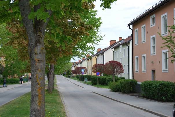 En färgbild som visar de färglada tvåvåningshusen på rad längs gatan.