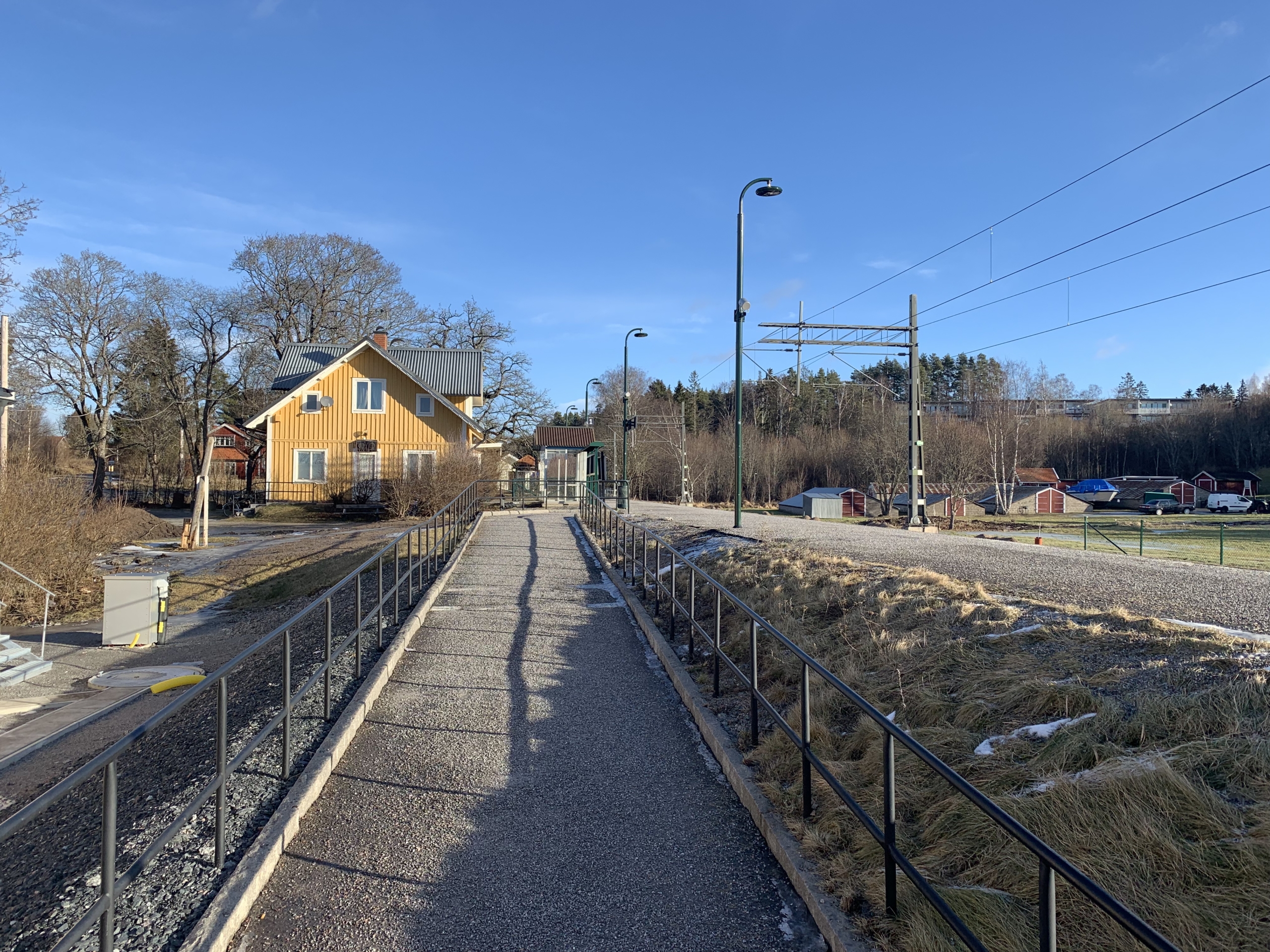 Gångväg leder fram till det gula stationshuset.