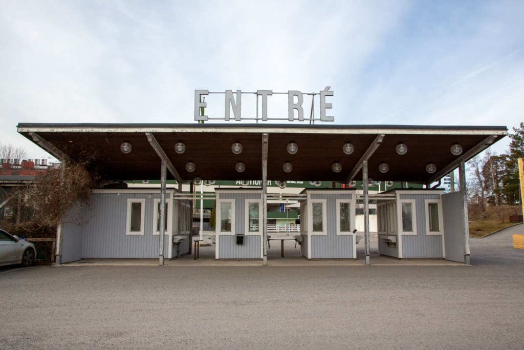 Foto. Entréskylt över biljettkassor målade i ljusblå färg.