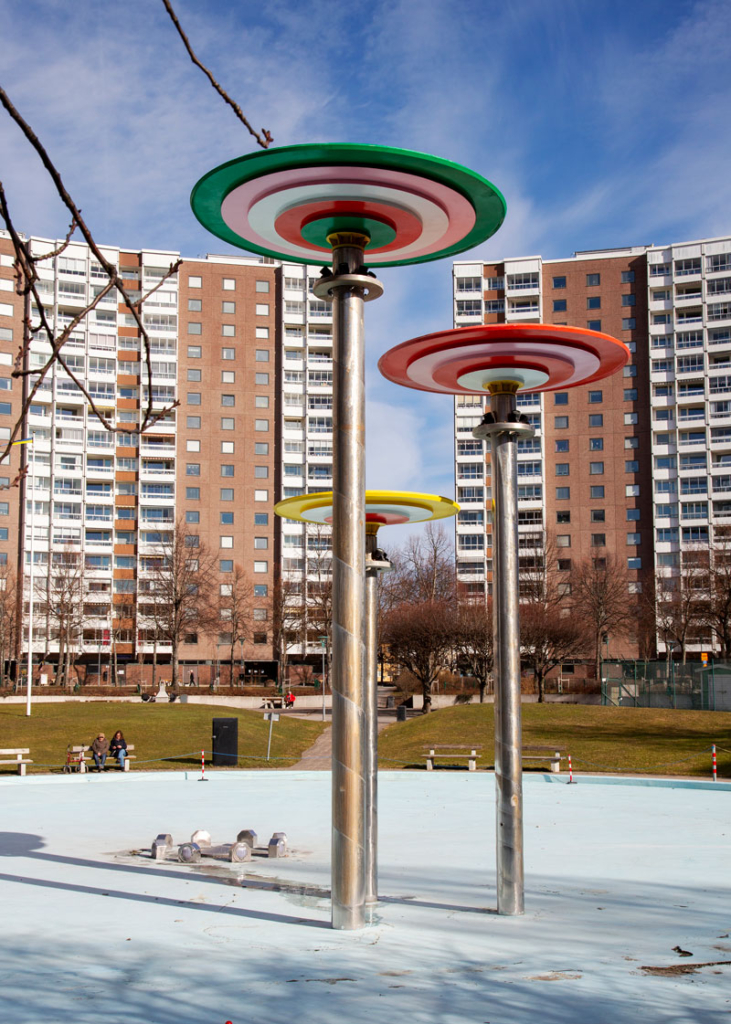 Fotografi. Färglada skulpturer utanför lägenhetshus.